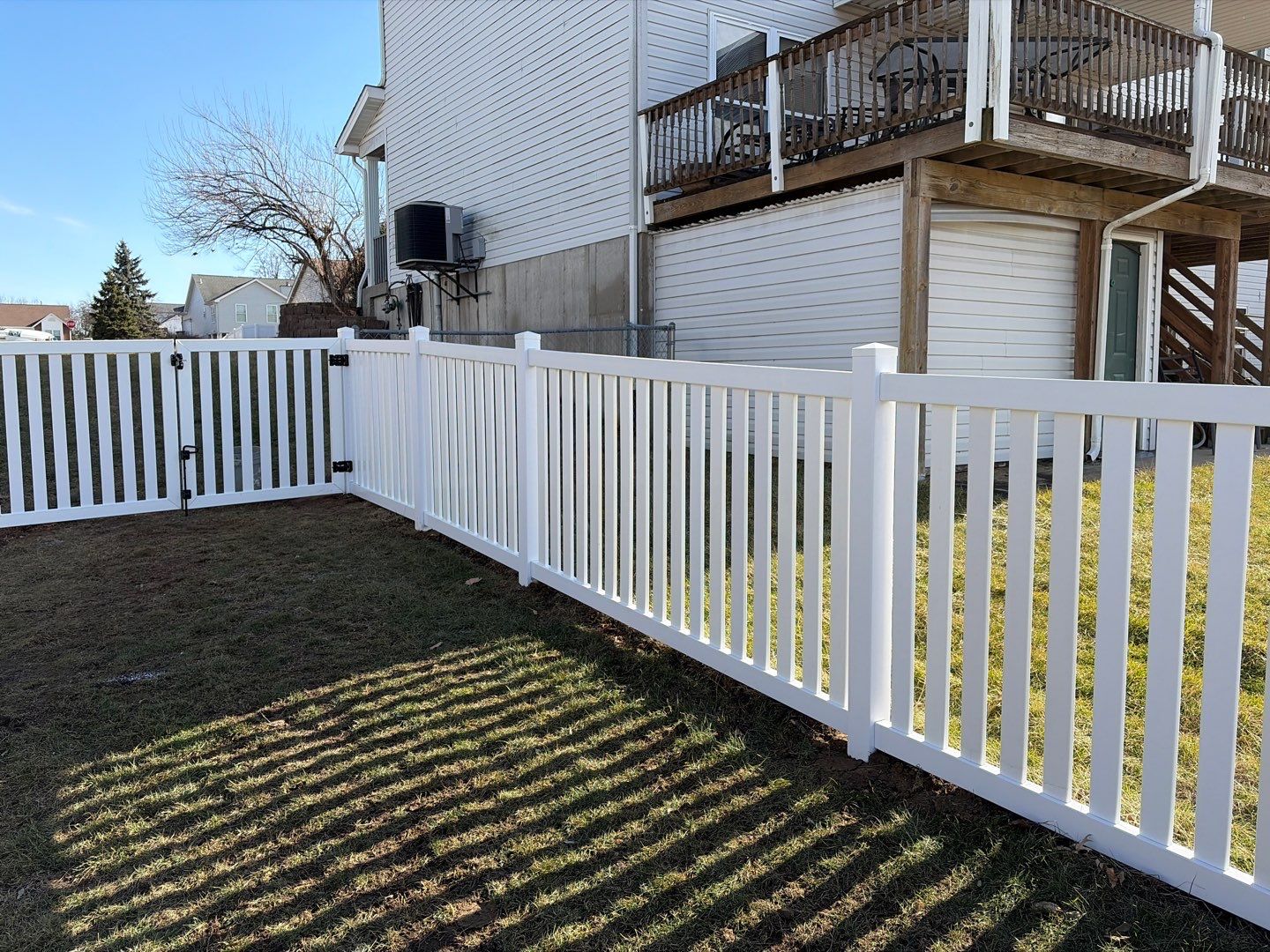 White vinyl fence enclosing residential backyard