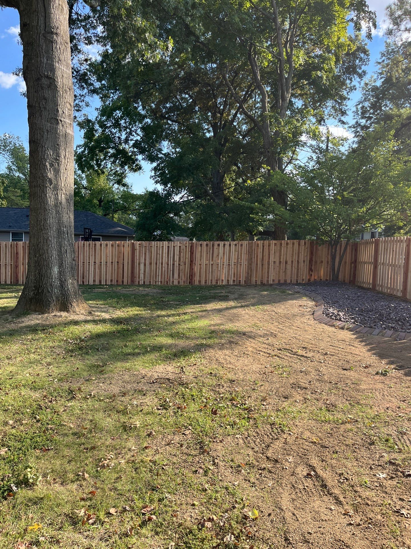 View from inside a backyard with a tall wood fence surrounding the property