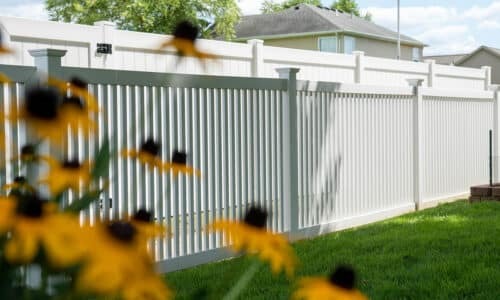 Fence-Deck-Depot-019-vinyl-fence-installati White fences with yellow flowers in foreground