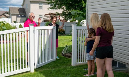 Neighbors greeting each other and opening gate