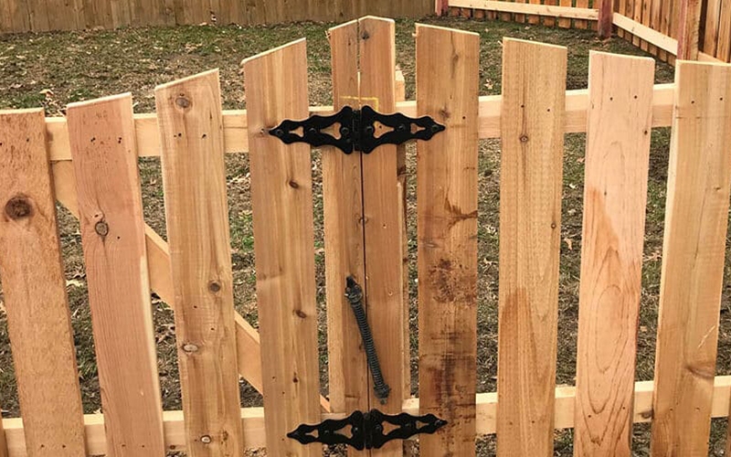 Wood fence with metal hinges