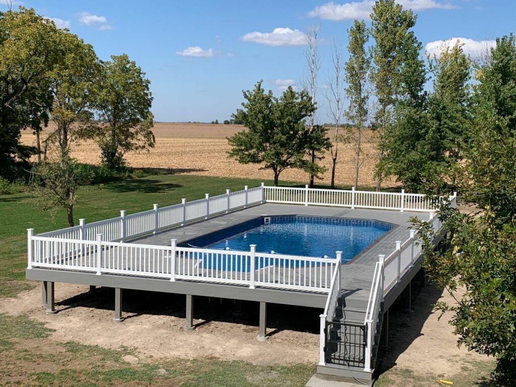 Large above-ground pool with deck and railing around perimeter