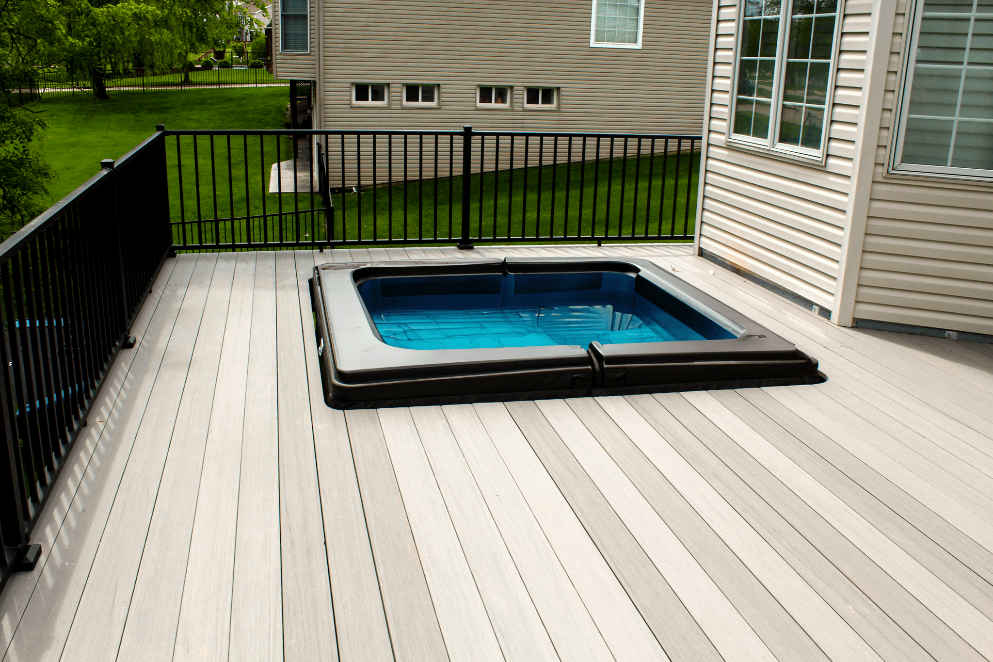 Hot tub built in to deck with railing