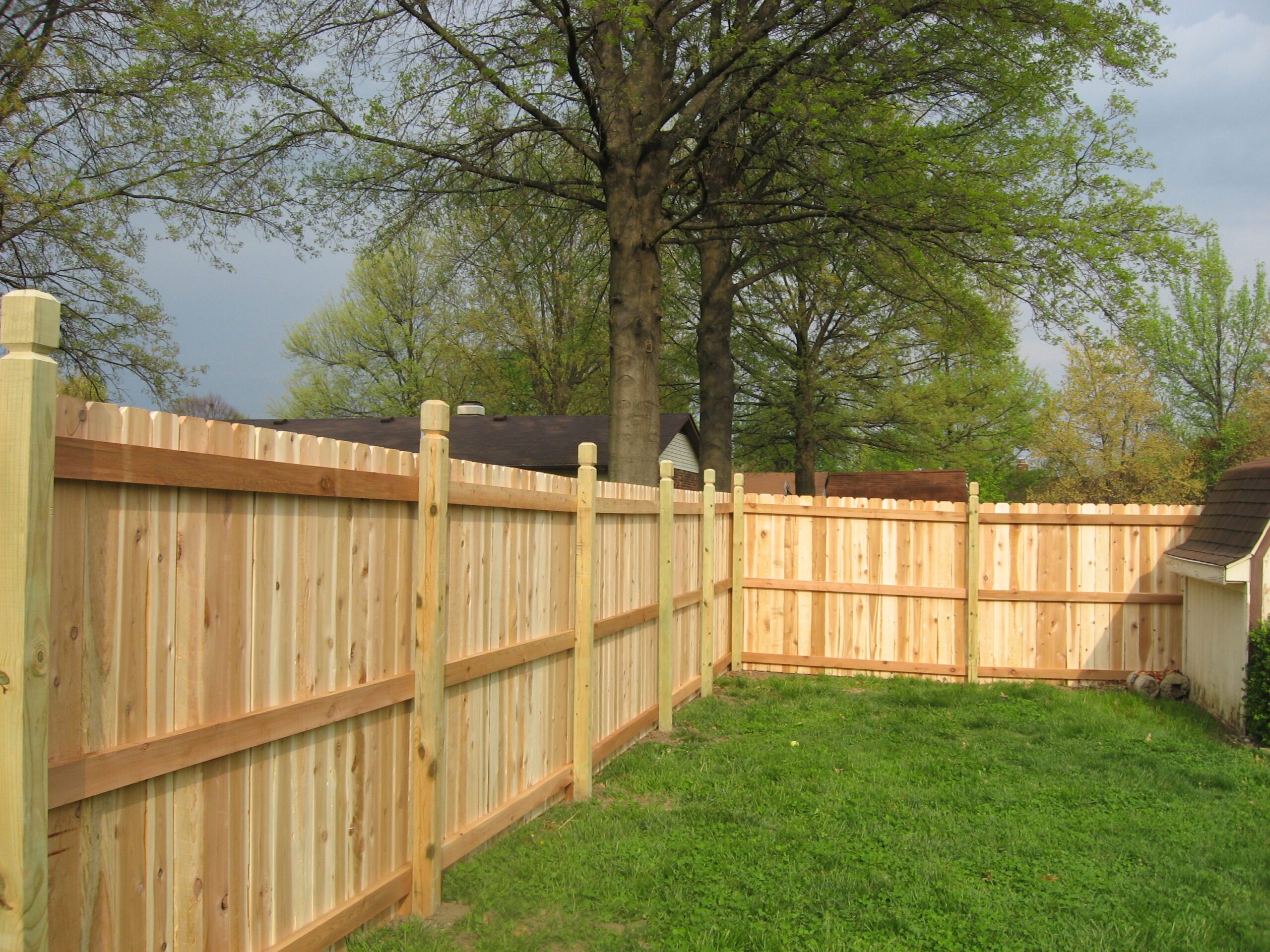 Wood privacy fence around green lawn