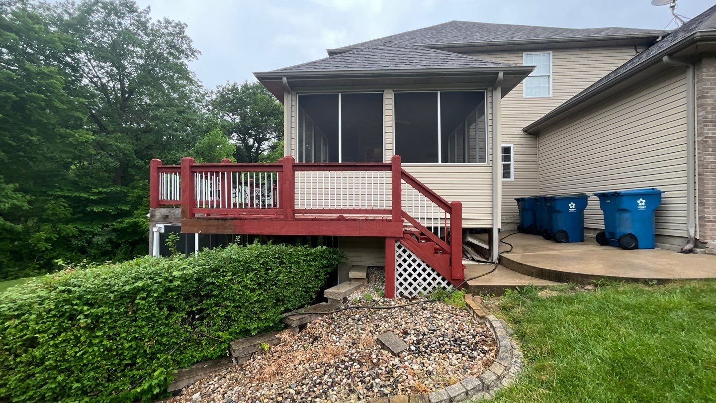 Before image of an old red wood deck with white lattice.