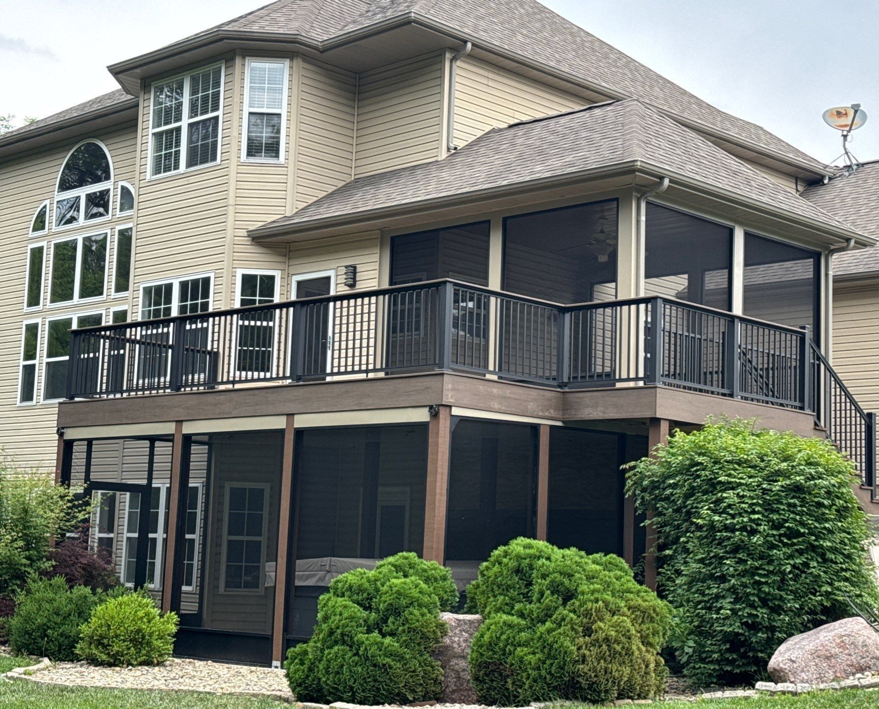 A new composite deck with a modern railing, a screened-in porch on the deck, and a screened-in underdeck system.