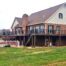 A large deck wraps around a suburban home