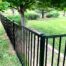 Aluminum fence surrounds lush backyard garden area