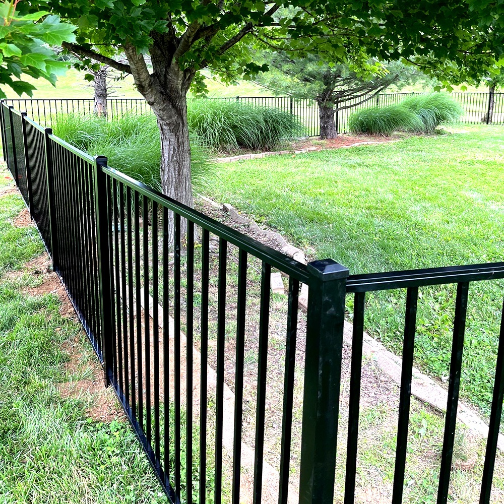 Aluminum fence surrounds lush backyard garden area