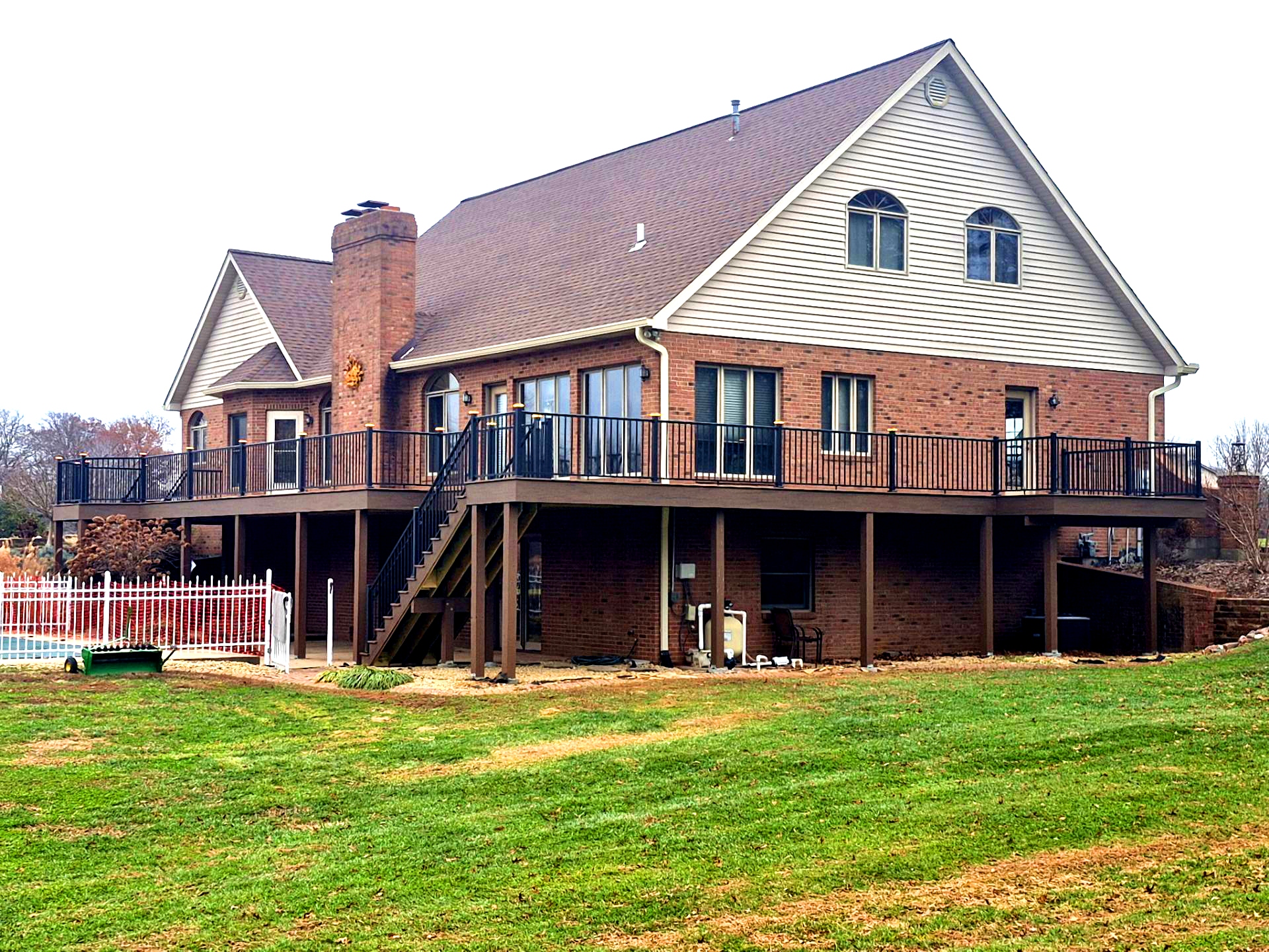 A large deck wraps around a suburban home