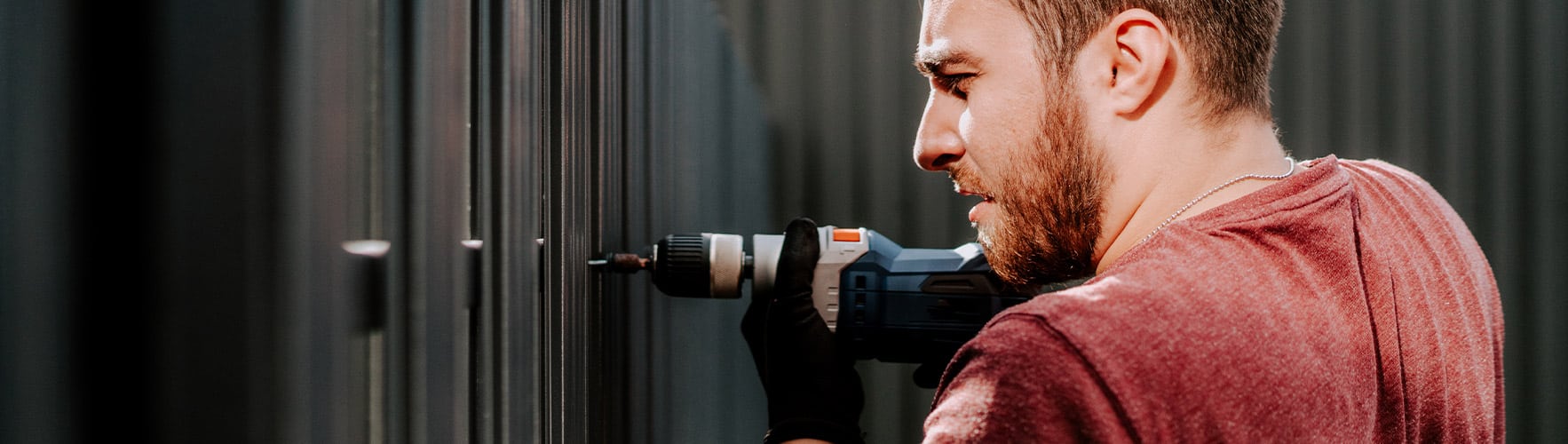 Man drilling fence