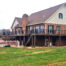 A large deck wraps around a suburban home