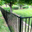 Aluminum fence surrounds lush backyard garden area